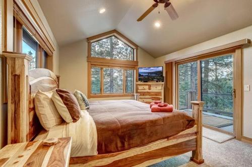 a bedroom with a bed and a tv and windows at On Tahoe Time - Pets Pool Table Game Room in South Lake Tahoe