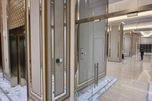 a hallway with glass doors in a building at Apartement Trans Park Cibubur By Raya Property With Netflix in Kalimanggis