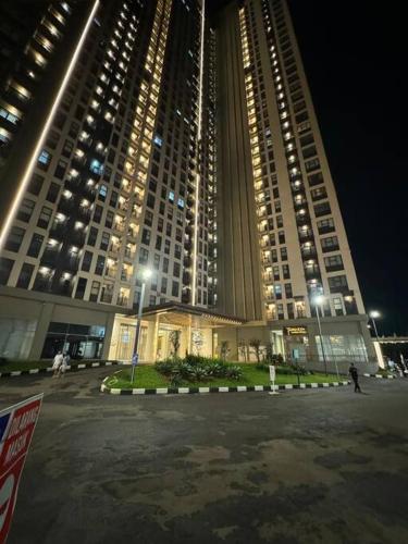 a large building with lights in front of it at night at Apartement Trans Park Cibubur By Raya Property With Netflix in Kalimanggis