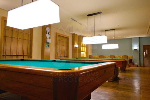 a pool table in a room with chairs and lights at PICO DE LORO Pool Accessible CAROLA 3 Bedroom Units by SEE Condominiums in Cutad