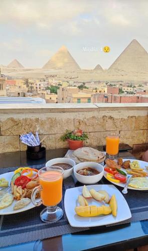 une table recouverte d'assiettes de nourriture et de jus d'orange dans l'établissement City pyramids inn, au Caire