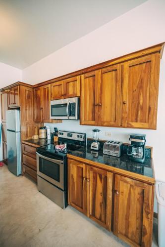 a kitchen with wooden cabinets and a stove top oven at Brahma Blue Resort in San Pedro