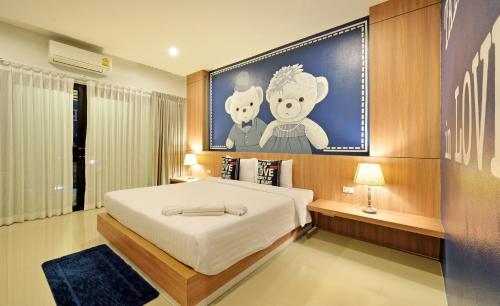 a bedroom with a large bed with a painting on the wall at Tairada Boutique Hotel in Krabi town
