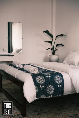 a bedroom with a bed with a mirror and a plant at This is it Beachfront - Rooms, Cafe & Events in Arambol