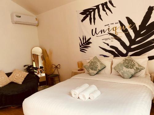 a bedroom with a white bed with towels on it at Tree nara garden houes kohlarn in Ko Larn