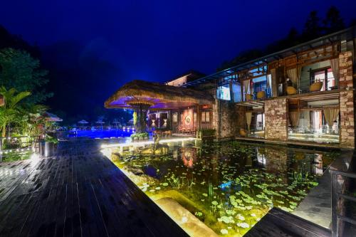 a large pond in front of a building at night at Pandora Vista Retreat in Zhangjiajie