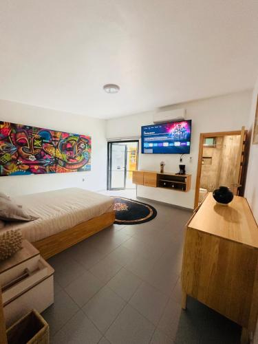 a bedroom with a bed and a flat screen tv at Departamento en MossoCafe Oaxaca in Oaxaca City