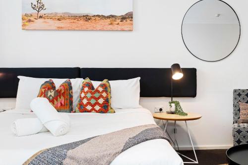 a bedroom with a white bed with a black headboard at Murray St Urban Retreat in Perth
