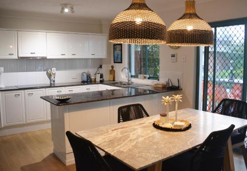 a kitchen with a table and a dining room at Bilinga Bliss - Luxury beachfront apartment in Gold Coast