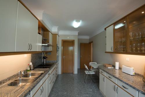 a kitchen with white cabinets and a sink at Estoril Biarritz - Luxury Sea View - Center Apart in Estoril