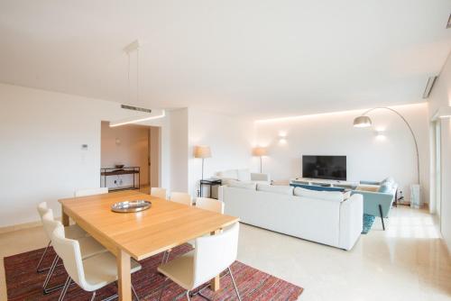 a dining room and living room with a table and a couch at Estoril Biarritz - Luxury Sea View - Center Apart in Estoril