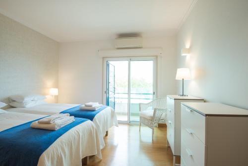a white room with two beds and a window at Estoril Biarritz - Luxury Sea View - Center Apart in Estoril