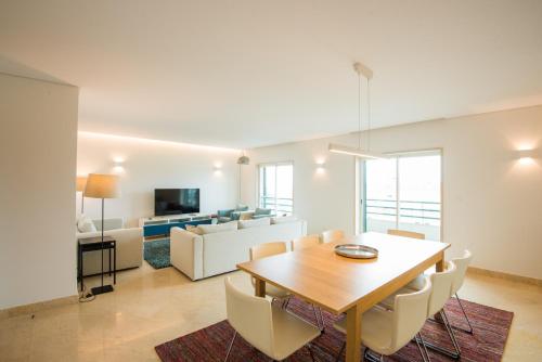 a dining room and living room with a table and chairs at Estoril Biarritz - Luxury Sea View - Center Apart in Estoril