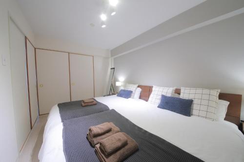 a bedroom with a large white bed with blue pillows at ノーザンヒルズ南6条 in Sapporo