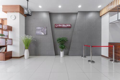 a lobby with two potted plants and a red ribbon at Staywell Hotel in Busan
