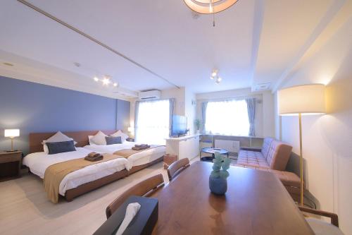 a hotel room with two beds and a couch at ノーザンヒルズ南6条 in Sapporo