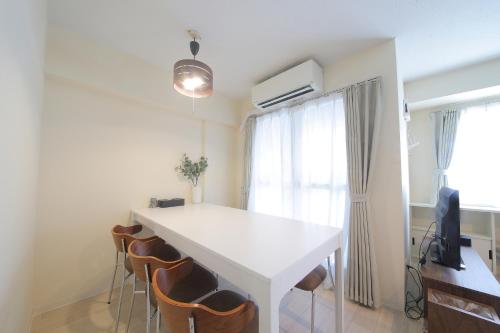 a white table and chairs in a room with a window at ノーザンヒルズ南6条 in Sapporo