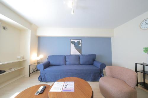 a living room with a blue couch and a table at ノーザンヒルズ南6条 in Sapporo