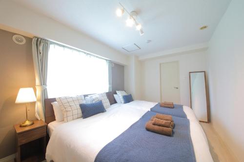 a bedroom with a large bed with a large window at ノーザンヒルズ南6条 in Sapporo