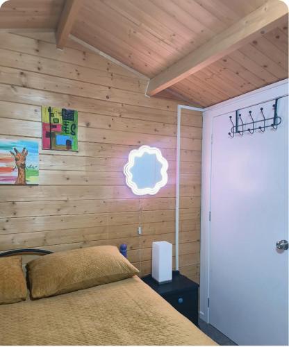 クイーンズタウンにあるGorgeous Cabin - Spa Pool!のベッドと木の壁がある寝室