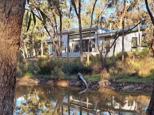 a house sitting on the side of a river at Green Bush Haven in Muckleford South