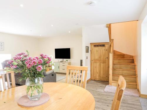 a vase of flowers on a table in a living room at Ffynnon Bach in Caernarfon