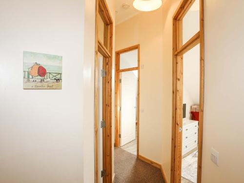 a hallway with a door and a mirror at Ffynnon Bach in Caernarfon