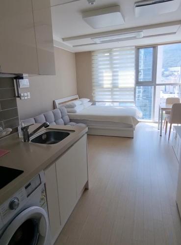a kitchen and living room with a bed in a room at Busan Station KTX House in Busan
