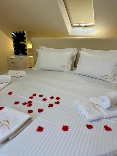 a bed with red hearts on the sheets at BlackMountain Hotel in Kolgecaj