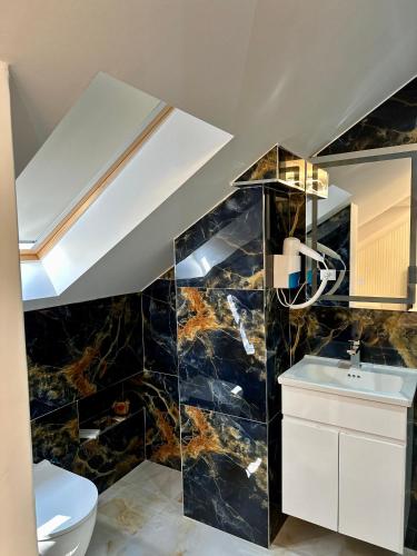 a bathroom with a black marble wall at BlackMountain Hotel in Kolgecaj