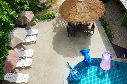 an overhead view of a pool with chairs and an umbrella at Khaolak Suthawan Resort - SHA Plus in Khao Lak