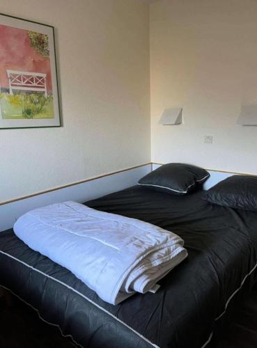 un lit dans une chambre avec une couverture noire et des oreillers dans l'établissement Résidence Quartier Falaise - maeva Home - Appartement 2 pièces 5 personnes - Sélection MAE-1801, à Avoriaz