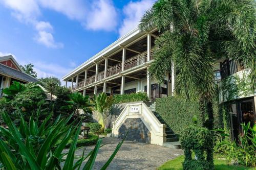an external view of a building with a palm tree at Anja Beach Resort & Spa in Phu Quoc