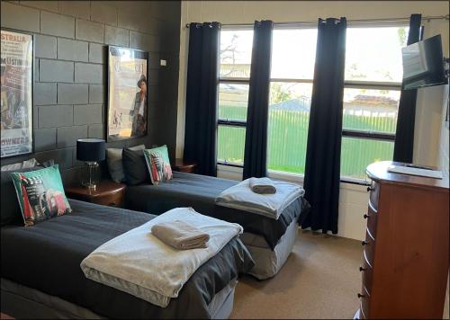a room with two beds and a large window at Flinders Ranges Motel - The Mill in Quorn