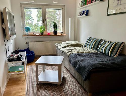a living room with a couch and a table at Close2City in Nacka