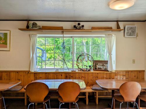 a dining room with a table and chairs and a window at Pension Cotton Farm in Niseko