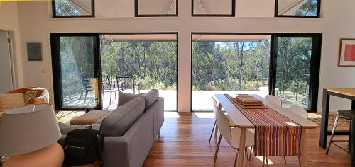 a living room with a couch and a table at Green Bush Haven in Muckleford South