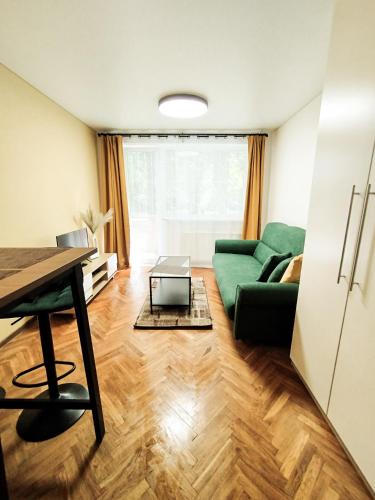 a living room with a green couch and a table at Cozy Noko Apartments in Kaunas