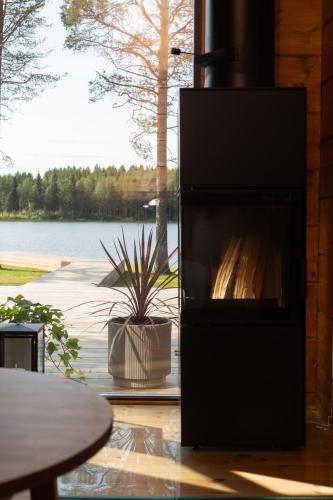 a fireplace in a house with a view of a lake at Lakeside holiday home in Rovaniemi