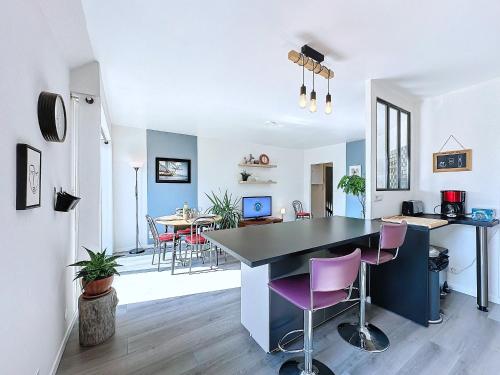 une cuisine et un salon avec une table et des chaises dans l'établissement Le Costour beau T3 avec balcon et vue verdoyante, à Le Relecq-Kerhuon