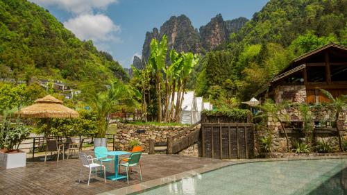 a resort with a swimming pool and mountains in the background at Pandora Vista Retreat in Zhangjiajie