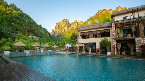 a large swimming pool with mountains in the background at Pandora Vista Retreat in Zhangjiajie