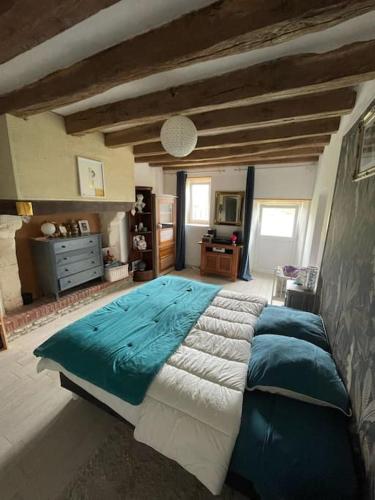 une chambre avec un grand lit dans une pièce dans l'établissement Séjour et weekend en famille chez l'habitant, longère bercéenne, 2 chambres 4 Pers, possibilité rajout berceau et 1 lit single soit 6 Pers maxi, à Marigné-Laillé