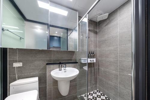 Un baño con lavabo, inodoro y espejo. en Urbanstay Sokcho Beach AB, en Sokcho