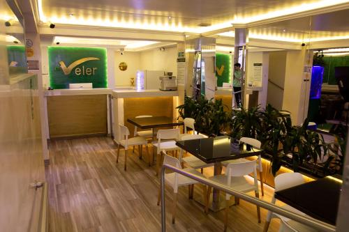 a restaurant with tables and chairs and a counter at Hotel Veler in Medellín