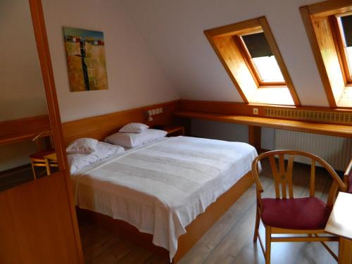 a bedroom with a bed and two windows at Hotel Kalma, Kalma Villa, Apart Hotel in Hévíz