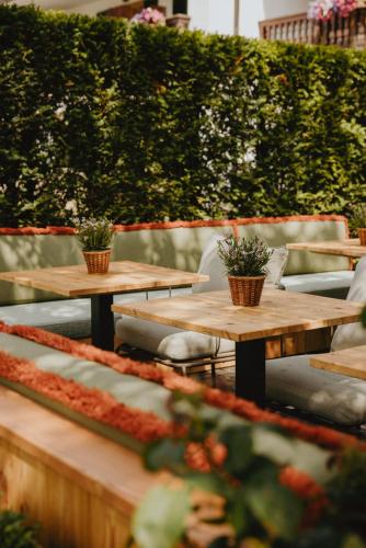 a row of wooden tables with potted plants on them at Spa & Resort Bachmair Weissach, LUXURY FAMILY RESORT in Rottach-Egern