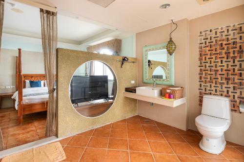 a bathroom with a toilet and a sink and a mirror at Kenting Shen's Homestay in Eluan