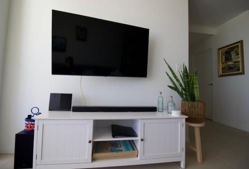 a white entertainment center with a flat screen tv on a wall at Maroochy City Lights@Thecosmopolitan Unit 20802 in Maroochydore