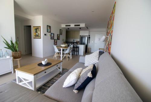 a living room with a couch and a table at Maroochy City Lights@Thecosmopolitan Unit 20802 in Maroochydore